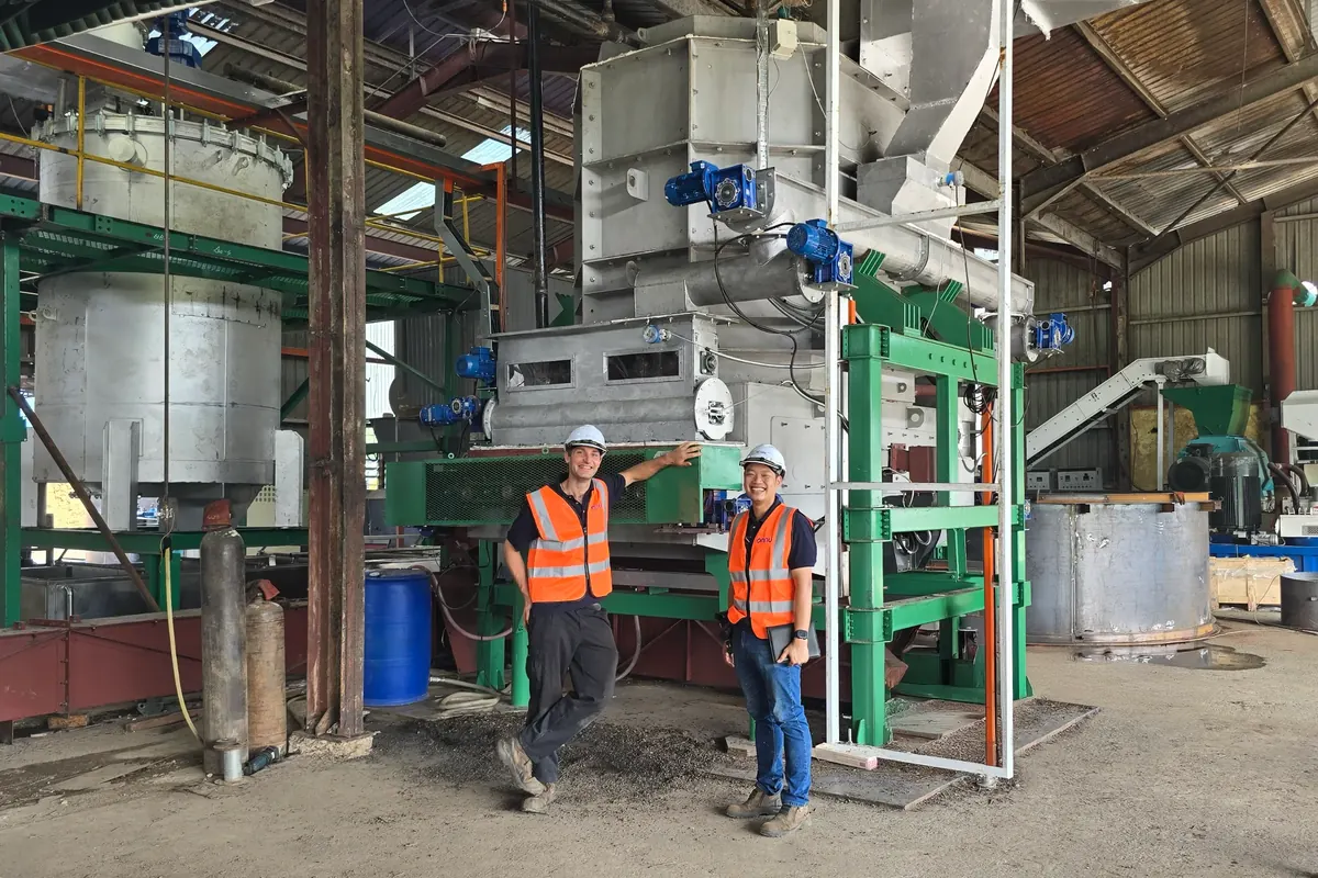 Two engineers beside the rotary valve and feed equipment at the agricultural plant